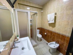 un bagno con un lavandino bianco e un water di Apartamento Ajanif Terraza Centro Martil Miramar 100 Metros playa a Martil