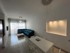 un soggiorno con un divano blu e un tavolo di Apartamento Ajanif Terraza Centro Martil Miramar 100 Metros playa a Martil