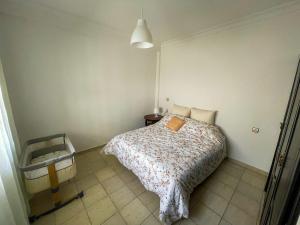 una piccola camera da letto con un letto e un tavolo di Apartamento Ajanif Terraza Centro Martil Miramar 100 Metros playa a Martil