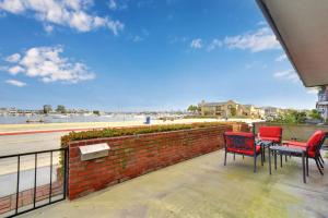 a patio with three chairs and a table and a brick wall at 925 W Bay Ave in Newport Beach