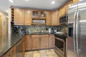 エイボンにあるBeaver Creek West S2 - 3 Bedroom condoのキッチン(木製キャビネット、ステンレス製の電化製品付)