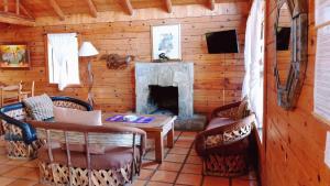 a living room with a fireplace in a log cabin at Sierra Paraiso Hotel in Mazamitla