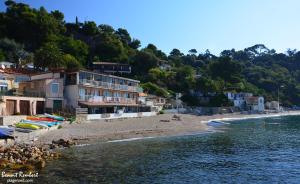 a beach with a group of buildings next to the water at Studio avec balcon - Plage à 10min à pied in Le Pradet