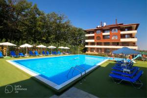 a swimming pool in front of a hotel at Forest View Apartment in Shkorpilovtsi
