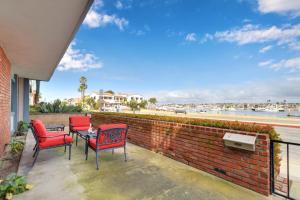 a patio with red chairs and a table and a brick wall at 925 W Bay Ave in Newport Beach