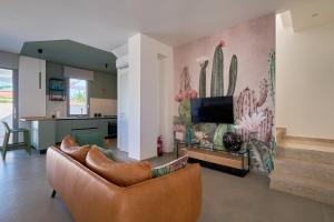 a living room with a couch and a tv on a wall at Villa Canepa in Marsala +28 photos