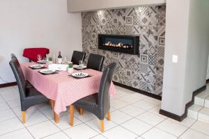 comedor con mesa y chimenea en Hillside Villa - Featherbrooke, en Krugersdorp