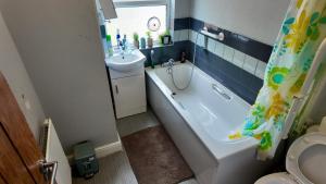 a bathroom with a tub and a sink and a toilet at 2 bedroom house perfect for contractors in Birmingham +17 photos
