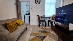 a living room with a couch and a flat screen tv at 2 bedroom house perfect for contractors in Birmingham
