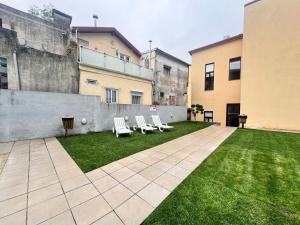 a courtyard with two lounge chairs and a lawn at OPORTO WINE LOFTS in Vila Nova de Gaia