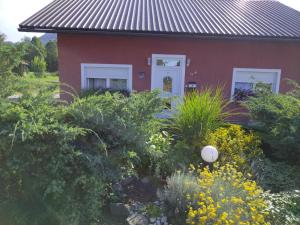 a red house with a garden in front of it at Nika in Ogulin