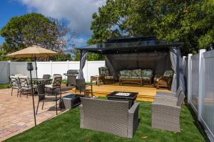 a backyard with a gazebo with chairs and tables at Newly Reno - Backyard Oasis, South Tampa Pool Home in Tampa