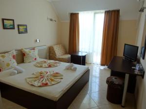 a hotel room with a bed with two plates on it at Guesthouse Kamelia in Ahtopol +88 photos