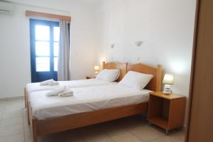 a bedroom with a bed with white sheets and a window at Sea View Studios in Amoopi +39 photos