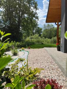 a garden with a gravel walkway and flowers at Domek nad Poniczanką in Rabka-Zdroj