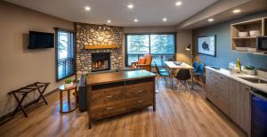 a kitchen with a fireplace and a table and chairs at Buffalo Mountain Lodge in Banff