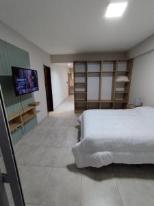 ein Schlafzimmer mit einem Bett und einem Flachbildfernseher in der Unterkunft Departamento en Barrio Sur in San Miguel de Tucumán + 6 Fotos