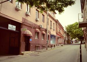 an empty street next to a building with an awning at Hotel Tabernei in Tbilisi City
