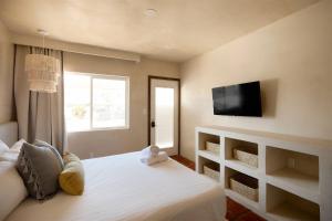 a bedroom with a bed with a tv on the wall at Sand Castle in Imperial Beach