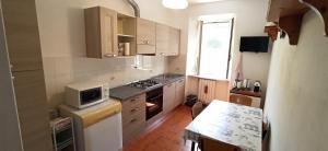 a small kitchen with a stove and a microwave at Casa Nanni in Portoferraio