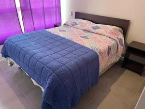 1 cama con edredón azul en una habitación en Departamento Alto Serena V, en La Serena