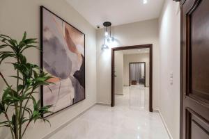 a hallway with a painting on the wall and a plant at Sleep Inn Apart-Hotel in Cairo