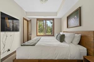 ein Schlafzimmer mit einem großen weißen Bett mit einem Fenster in der Unterkunft Grizzly Springs, Outdoor Pool, Hot Tub, Fireplace in Radium Hot Springs