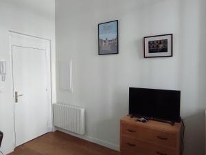 Una sala de estar con un televisor de pantalla plana sobre una cómoda. en Appartement Quai Abbé Grégoire, en Blois