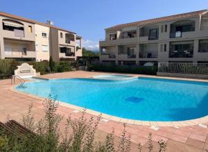 une grande piscine bleue devant un immeuble dans l'établissement Escapade aux vignes d'azur, au Beausset