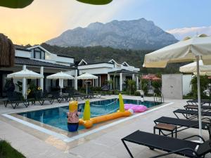 a swimming pool with a pool inflatable antidepressives and chairs at - Meta Homes - in Kemer