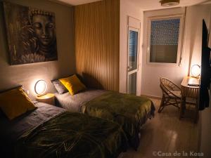 een kamer met 2 bedden en een tafel met een stoel bij Casa de la Kosa in San Miguel de Abona