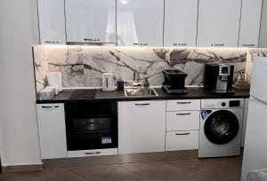 a white kitchen with a sink and a washing machine at Juls 2 bed flat- Bulgaria mall FREE parking in Sofia