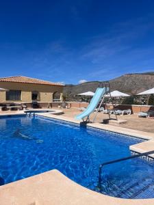 a swimming pool with a slide in a resort at Casa Duseña Luna in Hondón de las Nieves