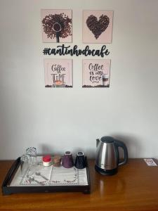 a counter top with a coffee pot and posters on a wall at Dolce Vita in Porto Belo
