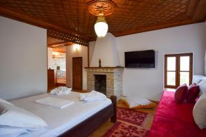 a bedroom with a large bed and a fireplace at Aqueduct inn in Gjirokastër