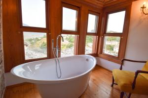 a bath tub in a room with windows at Aqueduct inn in Gjirokastër +68 photos