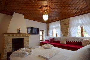 a bedroom with two beds and a fireplace at Aqueduct inn in Gjirokastër