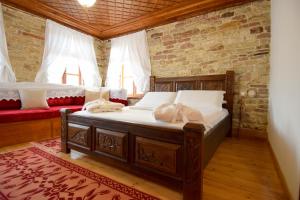 a bedroom with a bed and a red couch at Aqueduct inn in Gjirokastër