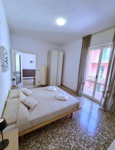 フィナーレ・リーグレにあるCasa dell'Altromondoの大きなベッドと大きな窓のある寝室