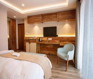 新德里Hotel TEO SUITES International Airport的一间卧室，配有一张床和一张带电视的书桌