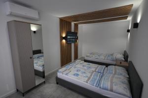una camera da letto con due letti e uno specchio di Pokoje Gościnne POL PETRO a Sałata