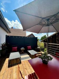 a patio with an umbrella and tables and chairs at LA P'TITE EVASION in Heimsbrunn