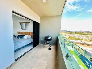 a bedroom with a bed and a balcony with a view at moderno con alberca cerca de la playa by G P S rentas in Mazatlán