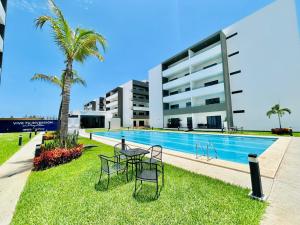 a hotel with a swimming pool and a palm tree at moderno con alberca cerca de la playa by G P S rentas in Mazatlán