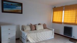 een slaapkamer met een bed, een ladekast en een raam bij Sunny Days Rent in Mar del Plata