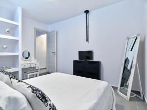 een witte slaapkamer met een bed en een spiegel bij Paros Iconic Apartments in Kampos Paros