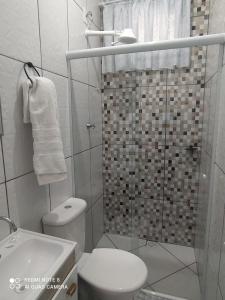 a small bathroom with a toilet and a shower at Pousada Quarto Privativo a 600 mts da basílica nova in Aparecida