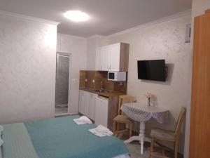 a small kitchen with a table and a small kitchen with a table and chairs at Apartments Dani in Pomorie