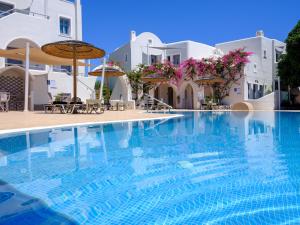 a swimming pool in front of a hotel with white buildings at Smaragdi in Perivolos