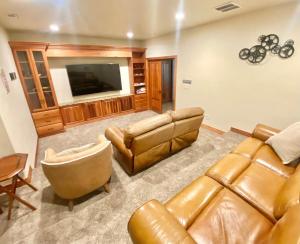 a living room with leather furniture and a flat screen tv at Luxury home w a View- biking and hiking near in Pocatello